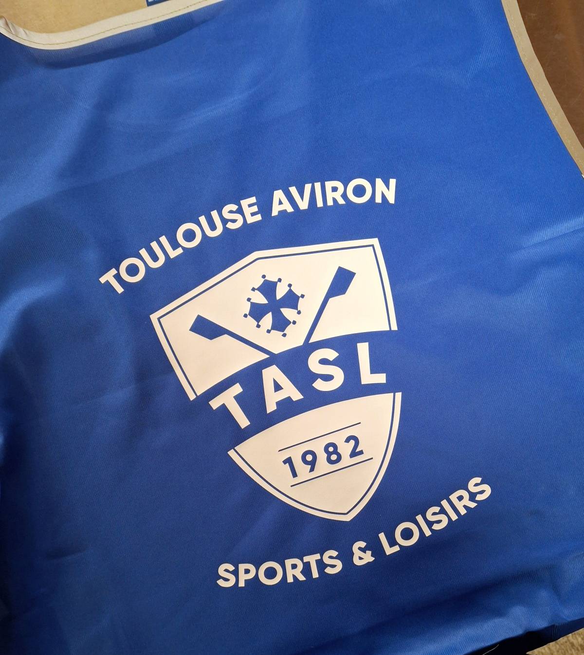 Impression d'un logo blanc au dos d'une chasuble bleu royal